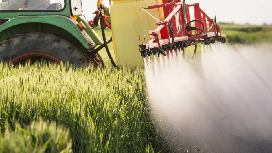 Ein Traktor versprüht Pestizide